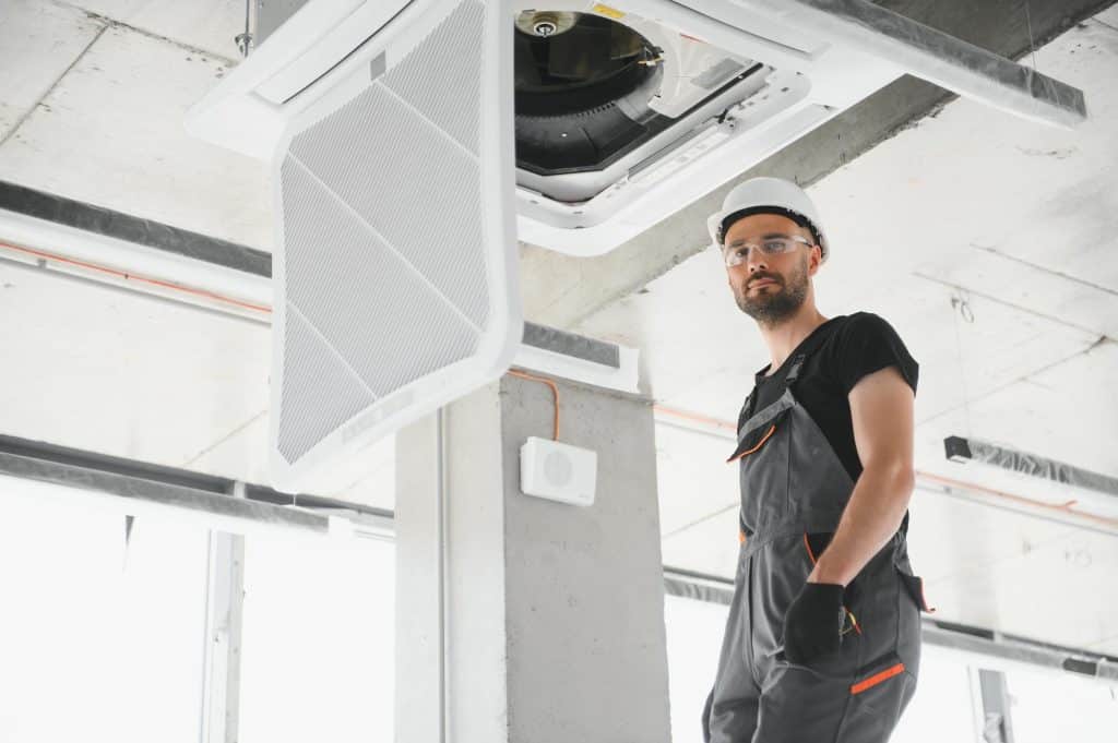 handwerker baut Lüftung ein