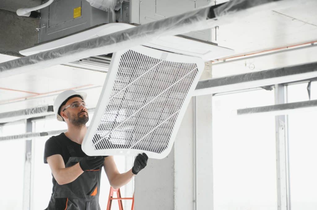Handwerker baut Lüftung ein